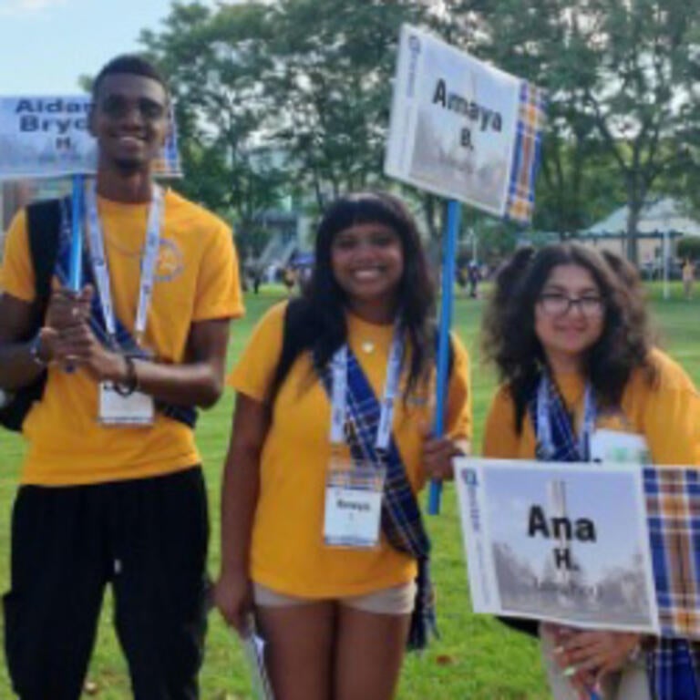 Orientation leaders holding signs and smiling