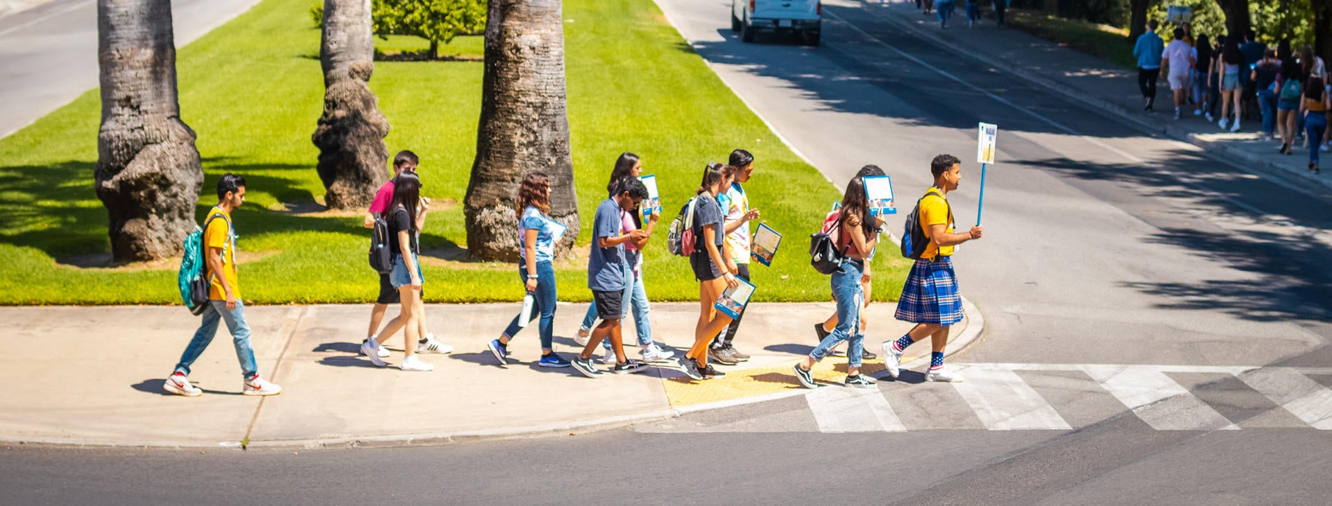Group of incoming UCR students cross Aberdeen Drive on their way to tour the campus residence halls.